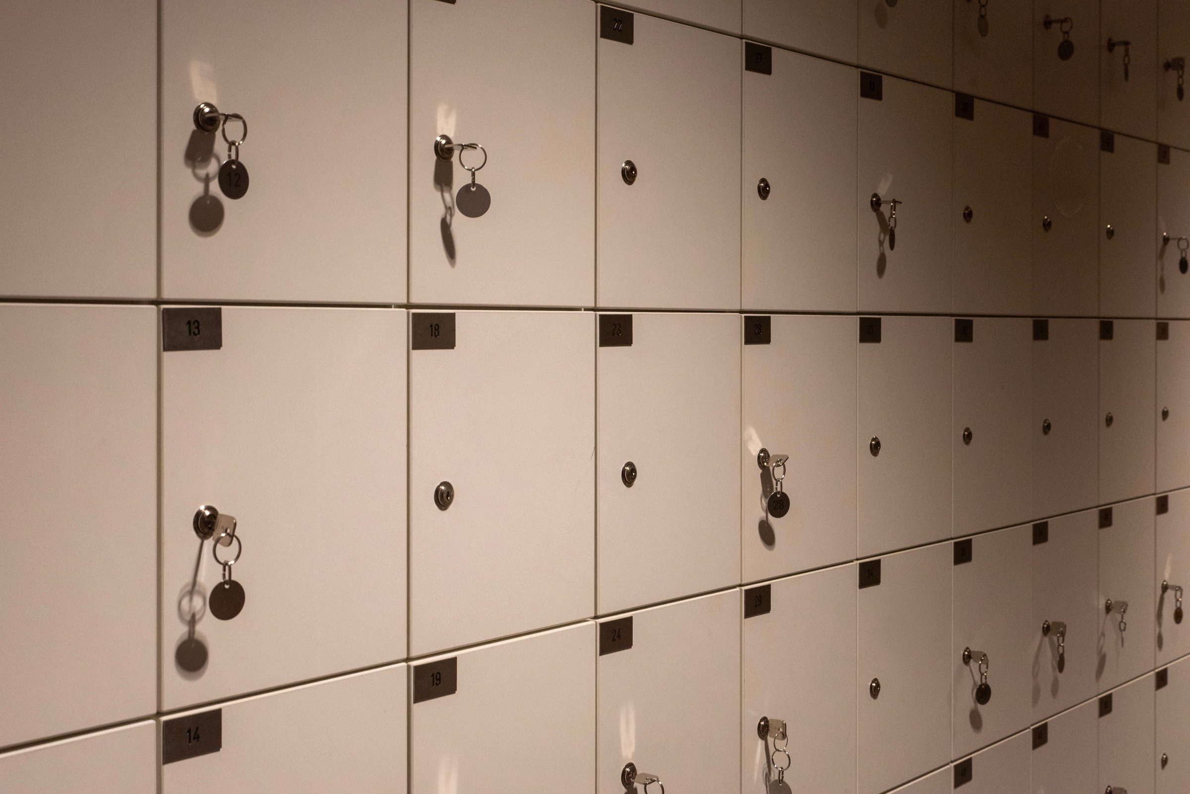 Dimly lit rows of lockers with keys, creating a geometric pattern in an indoor setting