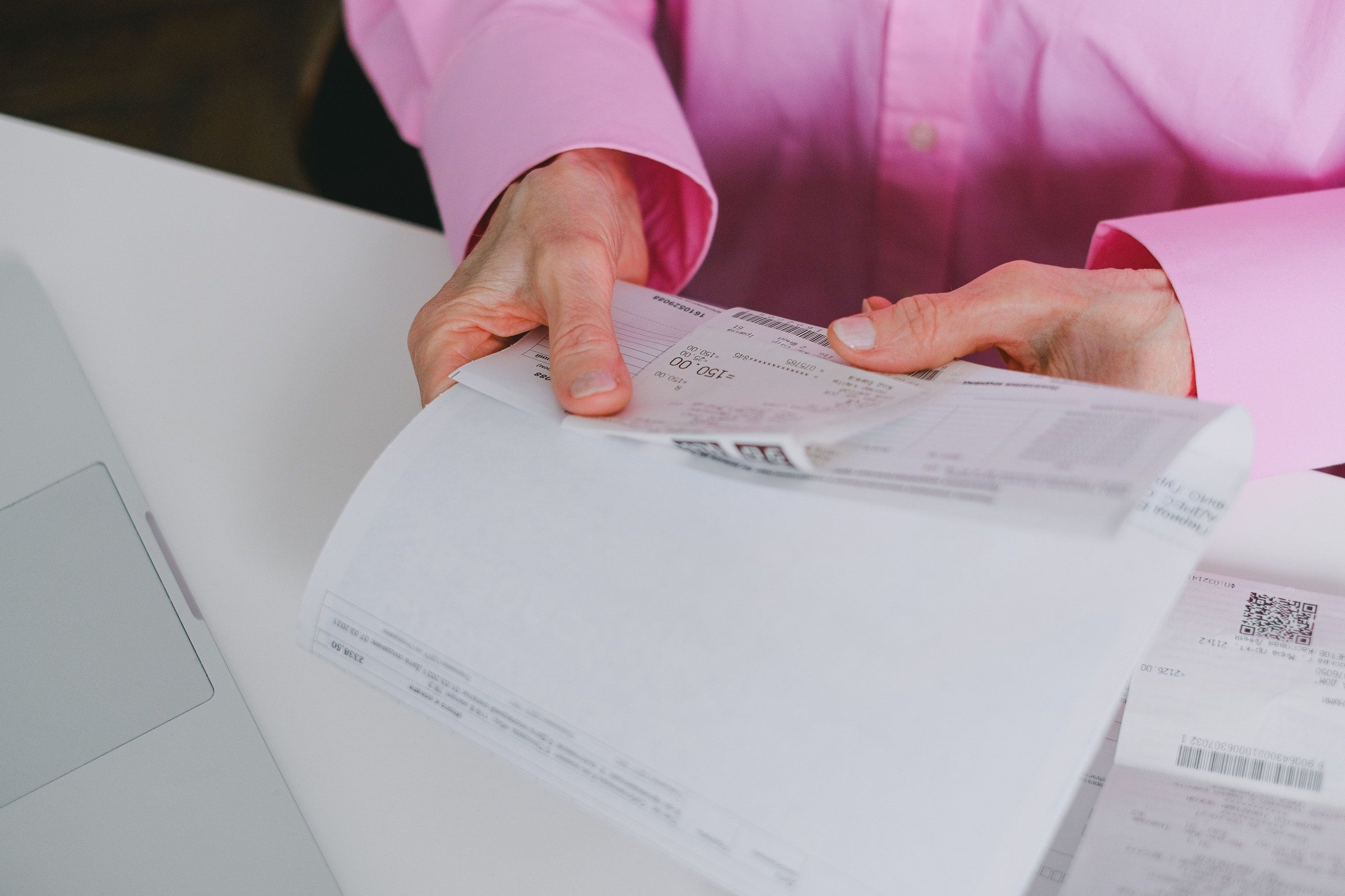 A person sorting paper receipts into order, illustrating the work of a cheque bounce lawyer in Dubai