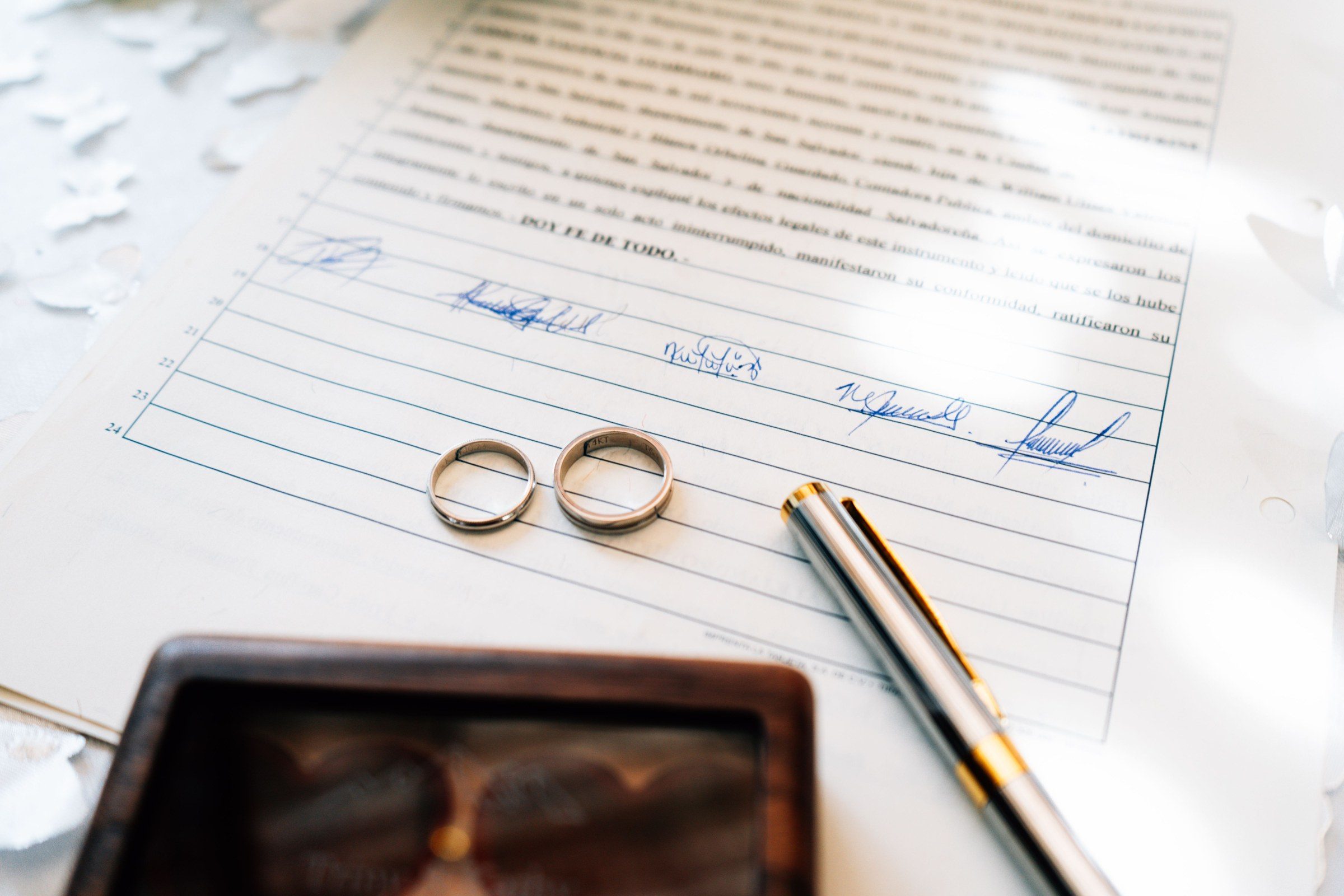 Elegant wedding rings laid on a signed marriage certificate, symbolizing commitment