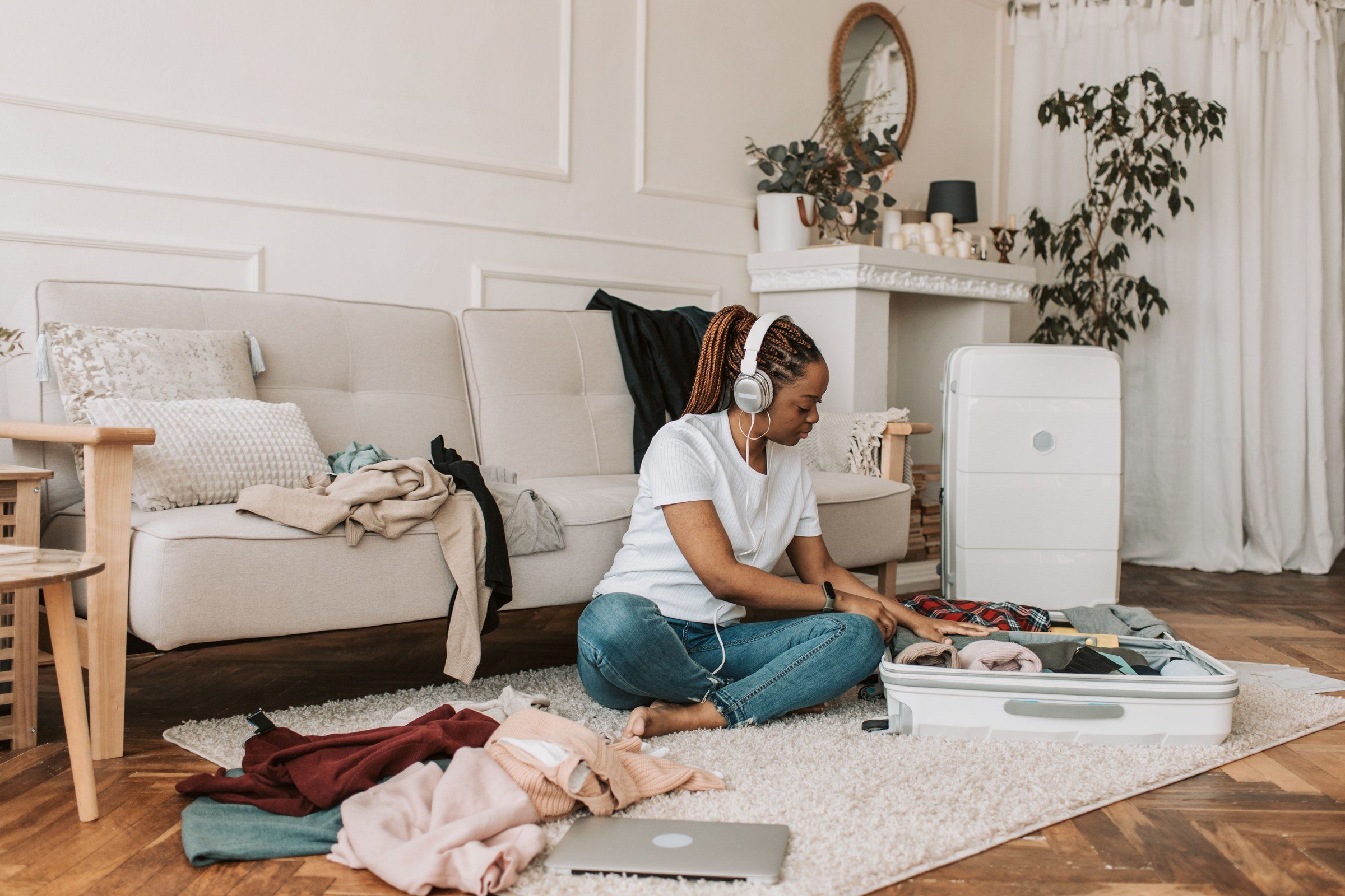 A woman packing a suitcase in her living room, illustrating the work of a divorce lawyer in Dubai for expats