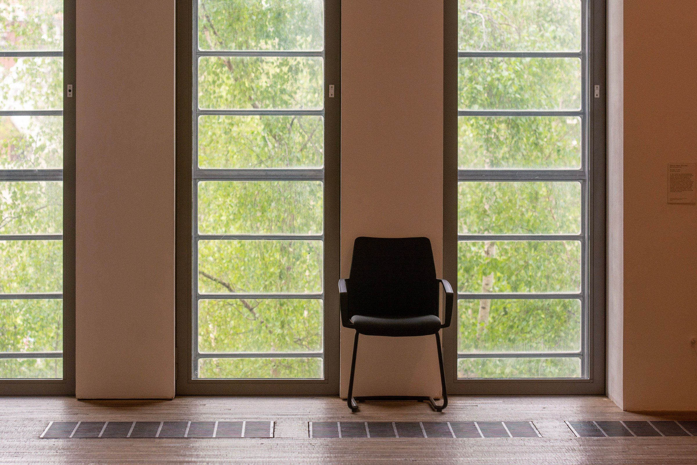 A single chair in a spare room with tall windows, illustrating the work of alimony lawyers in Dubai