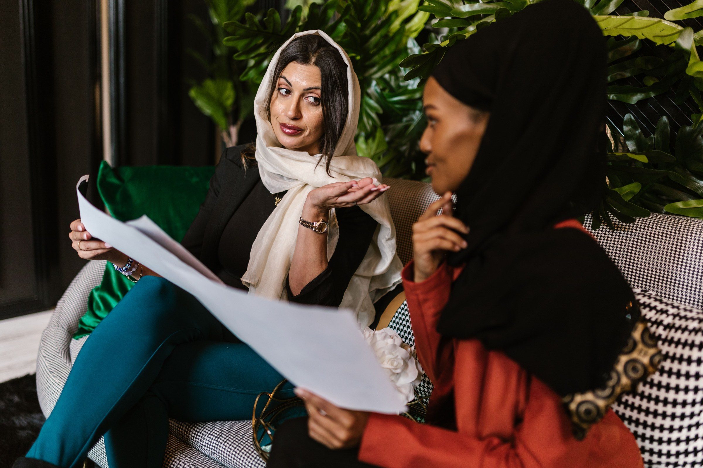 Two women in hijabs in a professional discussion, illustrating legal advice in Dubai