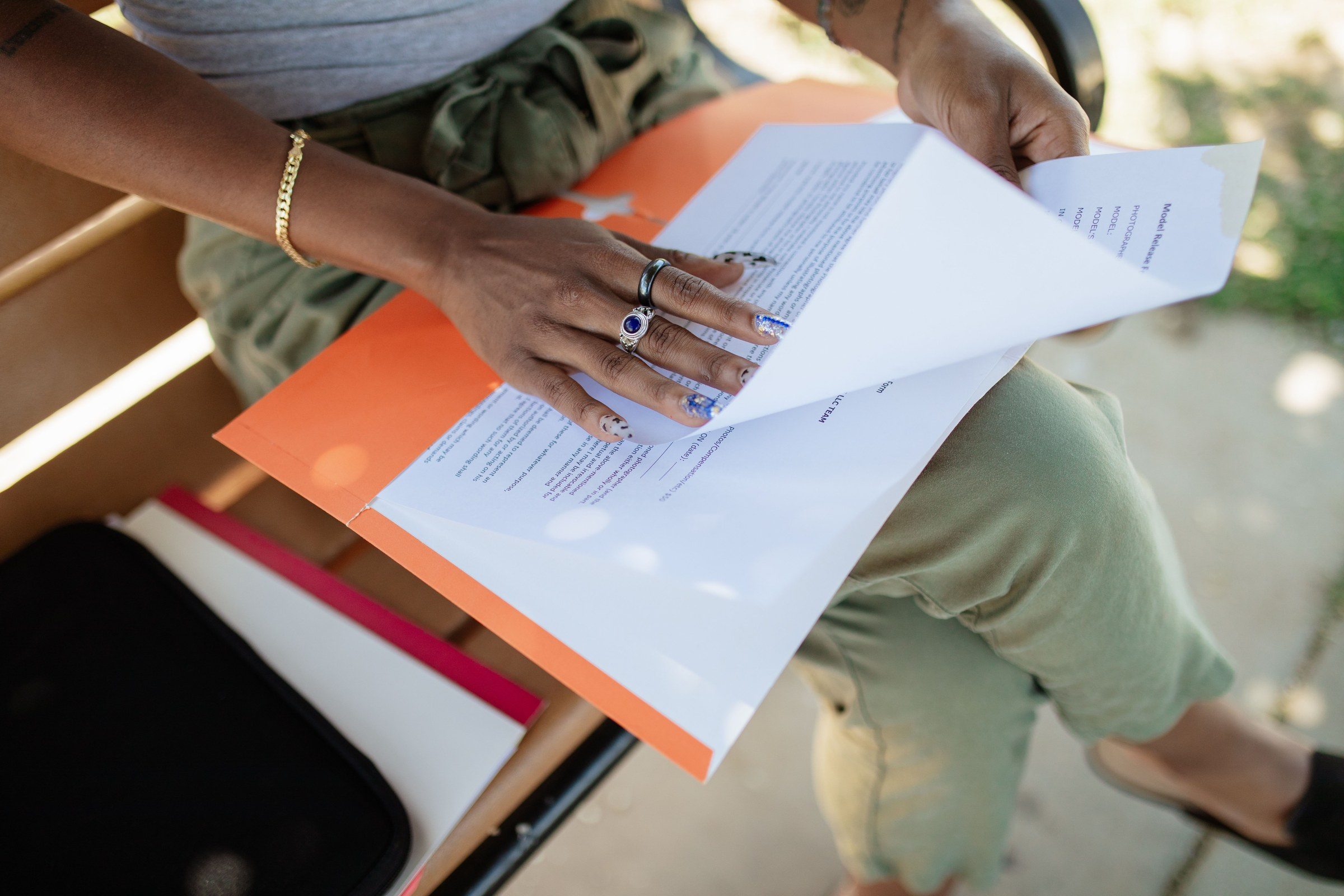 A woman checking documents on a bench in daylight, illustrating how to get a lawyer in Dubai