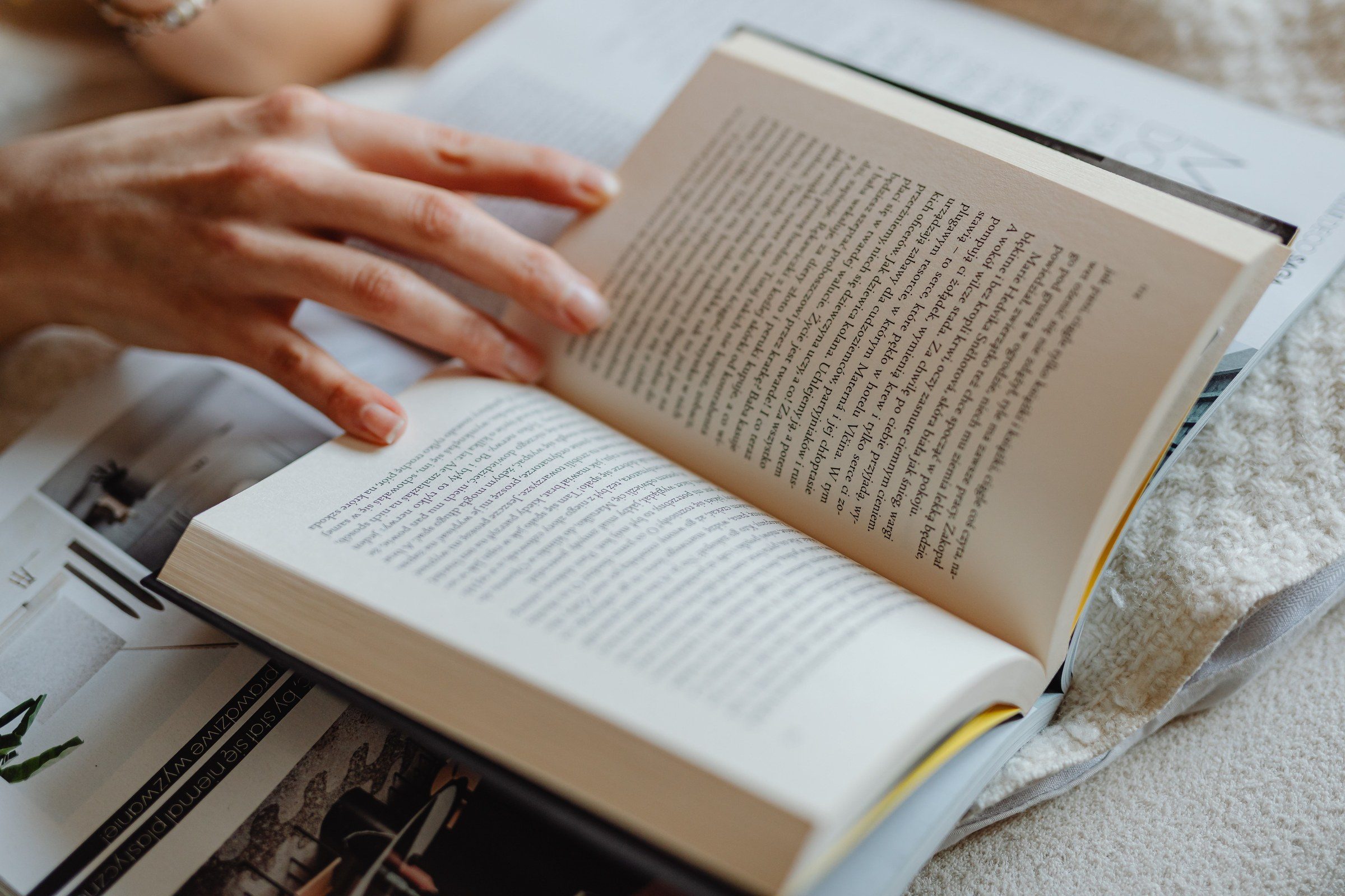 A person turning the pages of an open book, illustrating who regulates law firms in Dubai